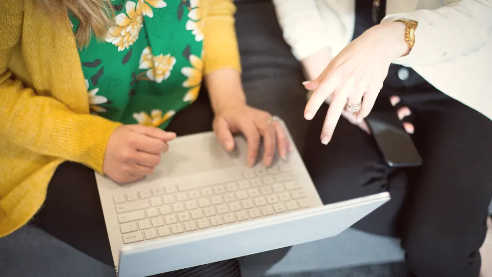 Two people working through a plan together at a laptop