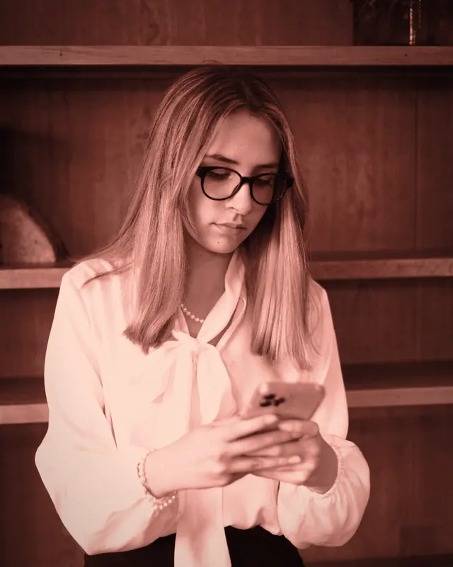 A woman reading a company page on her phone, deciding in under a minute whether to take it seriously