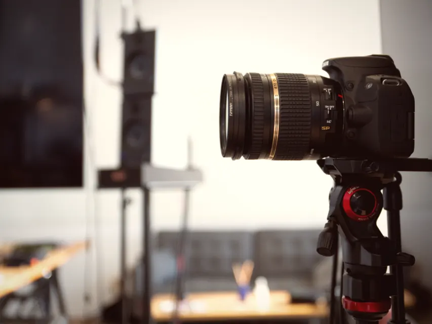 A camera on a tripod set up in a working space for a content day