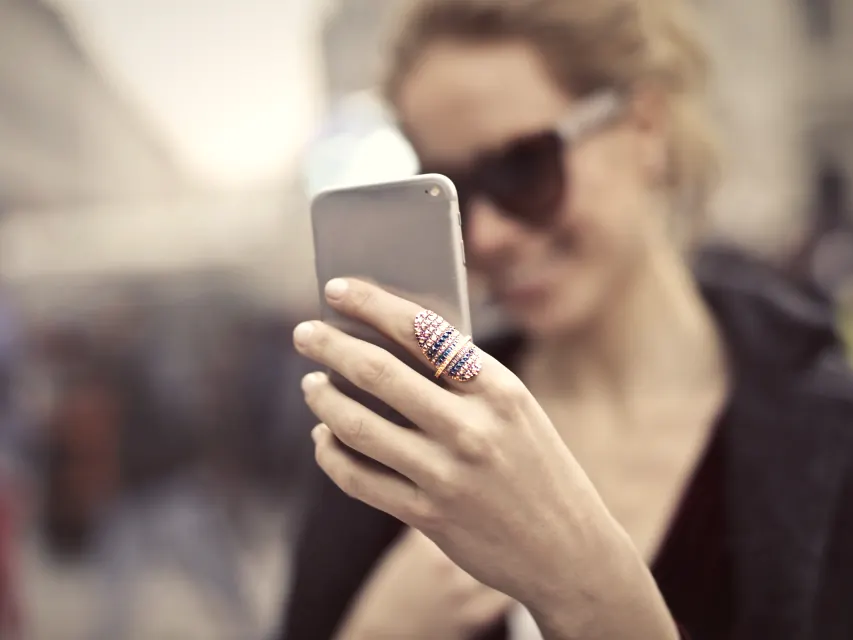 A woman holding up her phone mid post